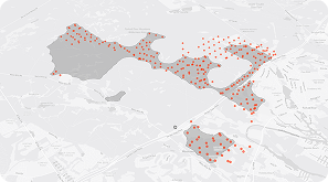 A grayscale map with shaded areas and clusters of red dots marking specific locations within the shaded regions. Major roads and place names are faintly visible in the background.