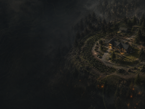 A house surrounded by trees sits on a hilltop at night, warmly lit amid darkness and mist, with faint glowing outlines and a winding driveway visible.