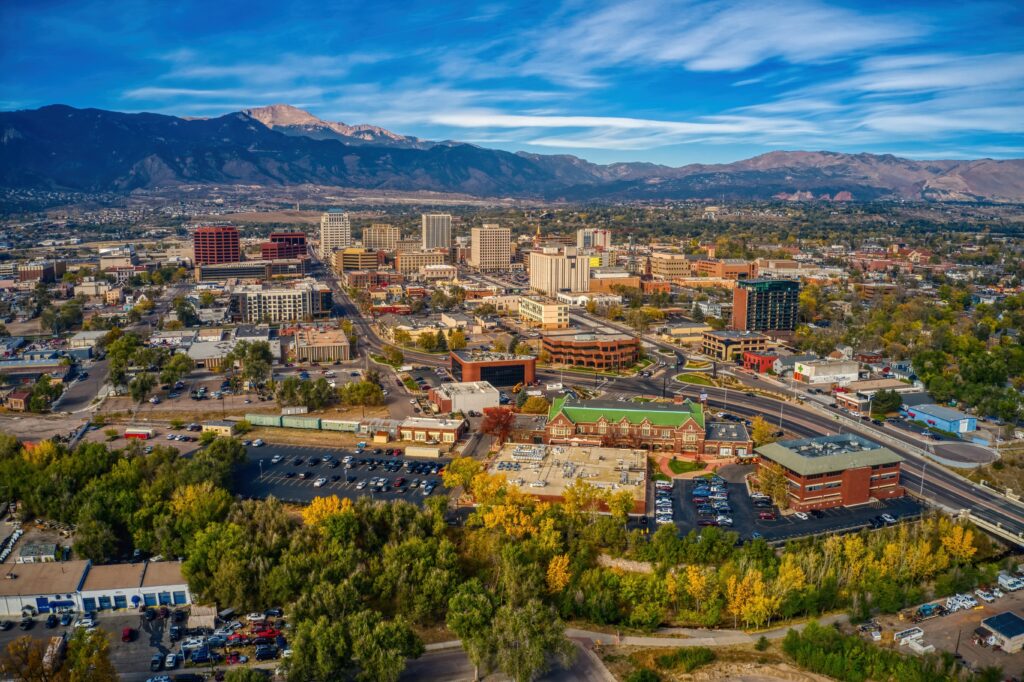 Aerial view of the Colorado Springs cityscape with Pikes Peak in the distance as wildfire smoke fills the sky.