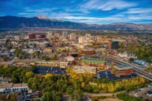 Aerial view of the Colorado Springs cityscape with Pikes Peak in the distance as wildfire smoke fills the sky.