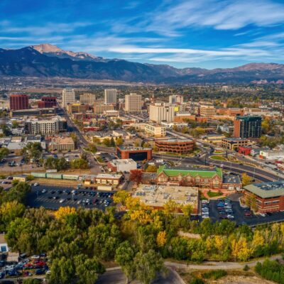 Aerial view of the Colorado Springs cityscape with Pikes Peak in the distance as wildfire smoke fills the sky.